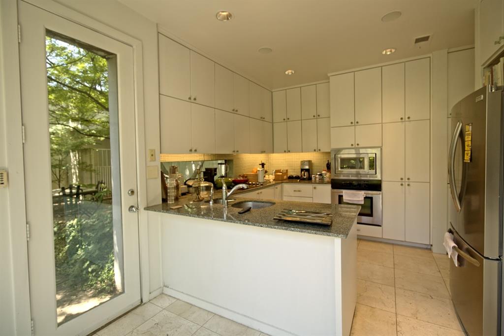 5108 Maple Springs Boulevard Dallas, TX 75235 - Photo 17 of 39 a kitchen with a refrigerator and a sink