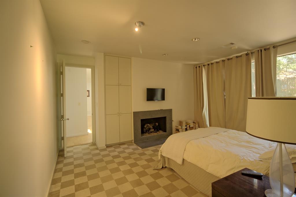 5108 Maple Springs Boulevard Dallas, TX 75235 - Photo 23 of 39 a bedroom with a bed and a fireplace