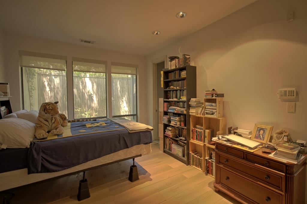 5108 Maple Springs Boulevard Dallas, TX 75235 - Photo 29 of 39 a bedroom with furniture and a book shelf