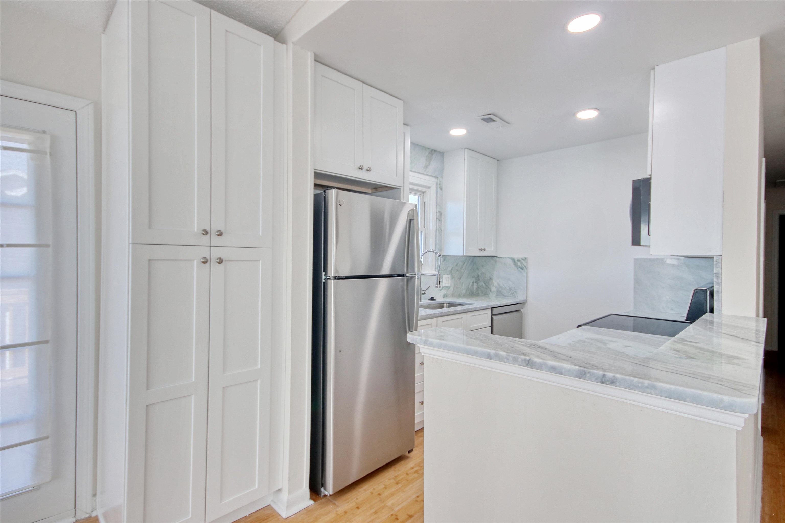 462 Bay Drive Murrells Inlet, SC 29576 - Photo 37 of 37 Kitchen featuring white cabinetry, appliances with stainless steel finishes, light wood-style flooring, recessed lighting, and open floor plan
