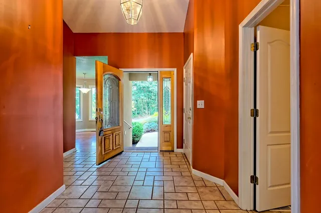 an empty room with wooden floor fireplace and windows