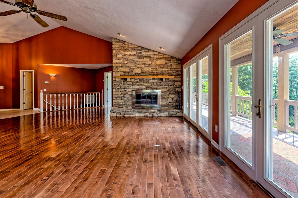 136 Elf School Road Hayesville, NC 28904 - Photo 15 of 84 an empty room with wooden floor fireplace and windows