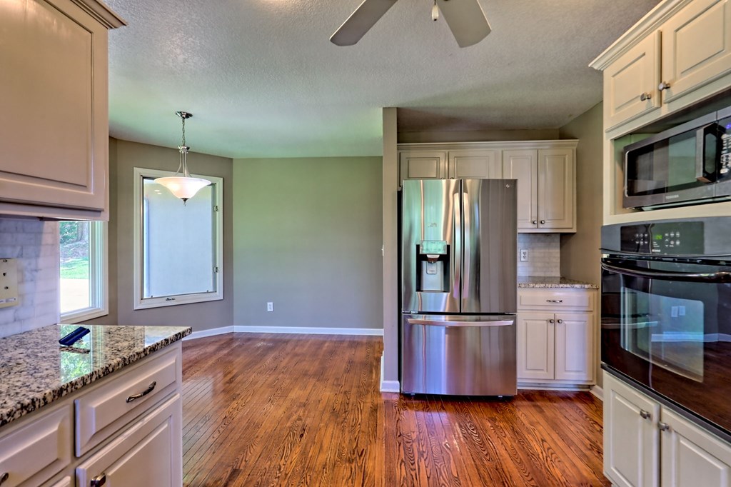 136 Elf School Road Hayesville, NC 28904 - Photo 33 of 84 a kitchen with stainless steel appliances granite countertop a refrigerator a stove and a wooden floors