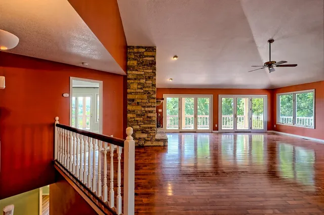 a view of empty room with wooden floor and a fireplace