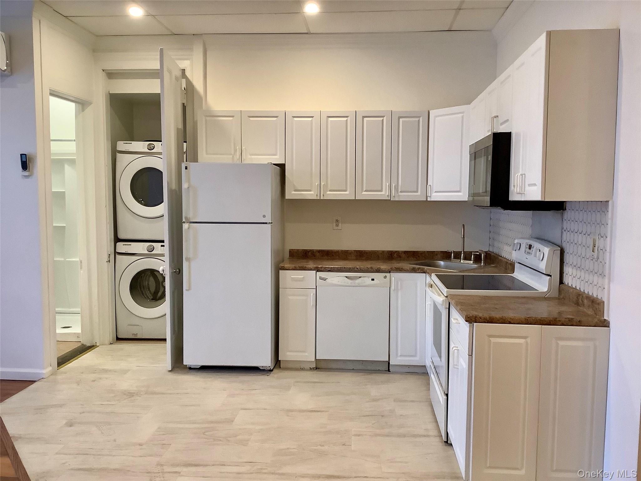 48 West Main Street Riverhead, NY 11901 - Photo 2 of 12 a kitchen with stainless steel appliances granite countertop a refrigerator a stove and a sink