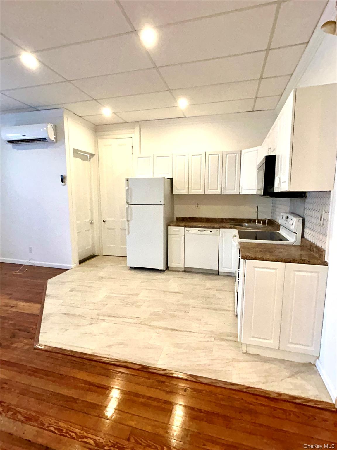 48 West Main Street Riverhead, NY 11901 - Photo 4 of 12 a kitchen with a wooden floor and cabinets
