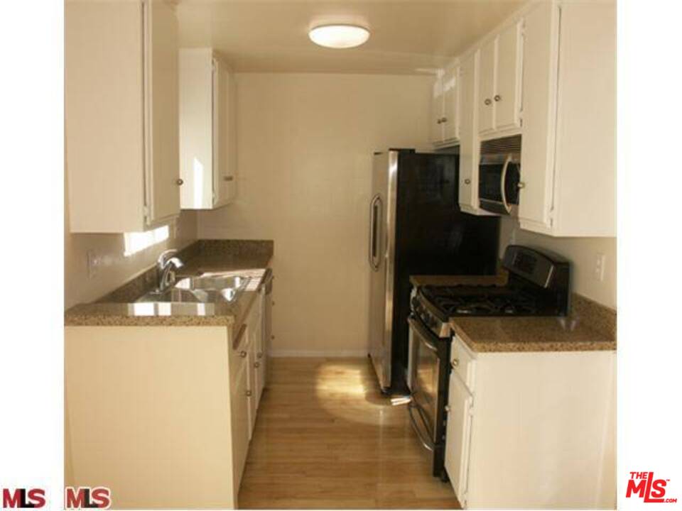 29239 Heathercliff Road, Unit 12 Malibu, CA 90265 - Photo 5 of 8 a kitchen with stainless steel appliances a stove a microwave a sink