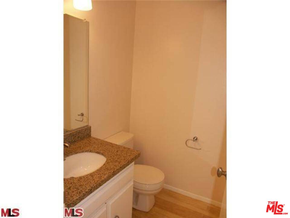 29239 Heathercliff Road, Unit 12 Malibu, CA 90265 - Photo 7 of 8 a bathroom with a granite countertop toilet and a sink