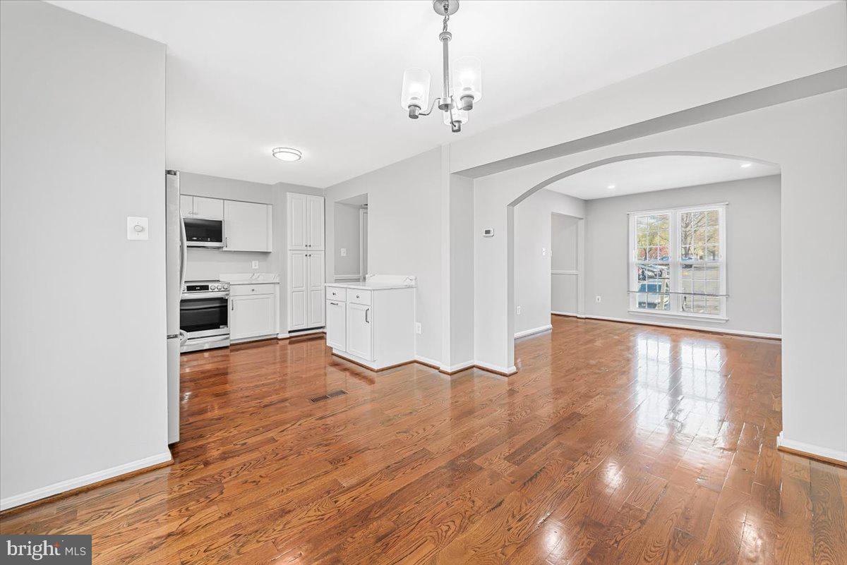 17641 Longview Lane Olney, MD 20832 - Photo 23 of 30 a view of empty room with wooden floor and kitchen