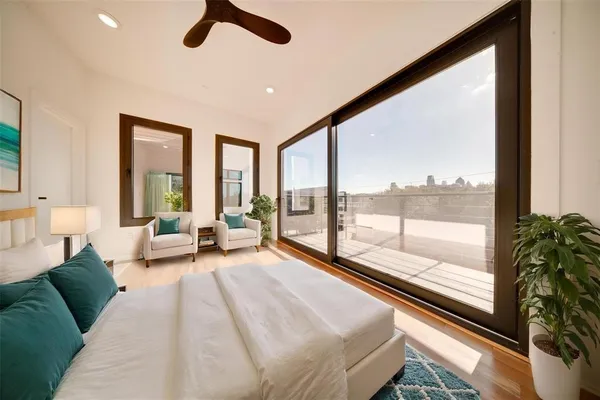 a spacious bedroom with a large bed and a large window with garden view