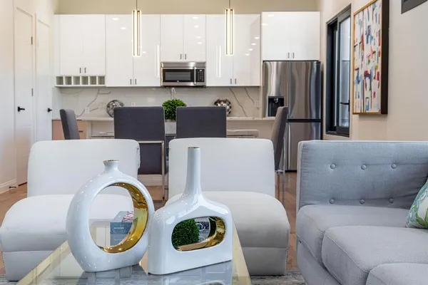 a living room with furniture a sink and a refrigerator