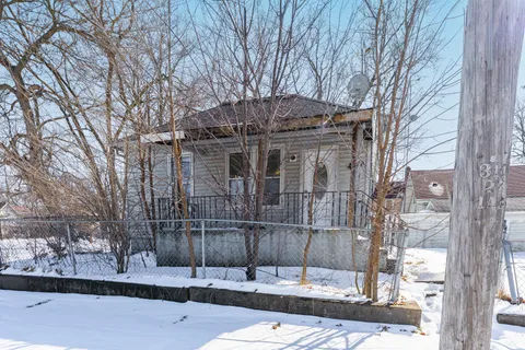 a front view of a building with a tree