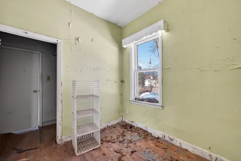 an empty room with wooden floor and a bathroom