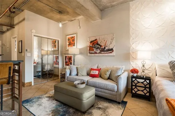 a living room with furniture and a painting on the wall