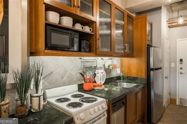 a kitchen with stainless steel appliances granite countertop a stove and a refrigerator