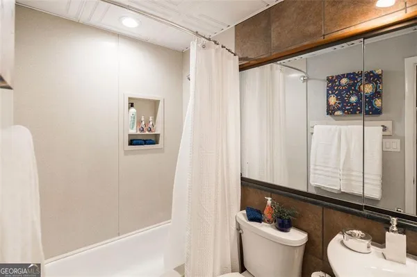 a bathroom with a sink a toilet and shower curtain