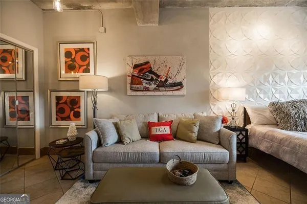 a living room with furniture and painting on the wall