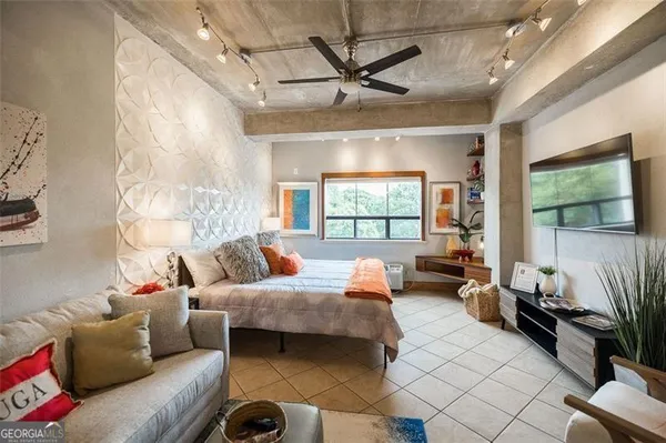 a bedroom with furniture and a large window