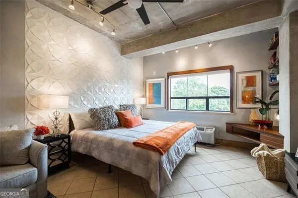 a bedroom with bed and a large window