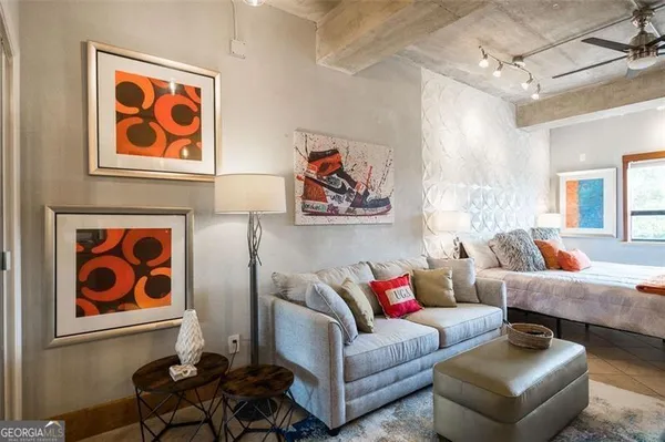 a living room with furniture and a painting on the wall