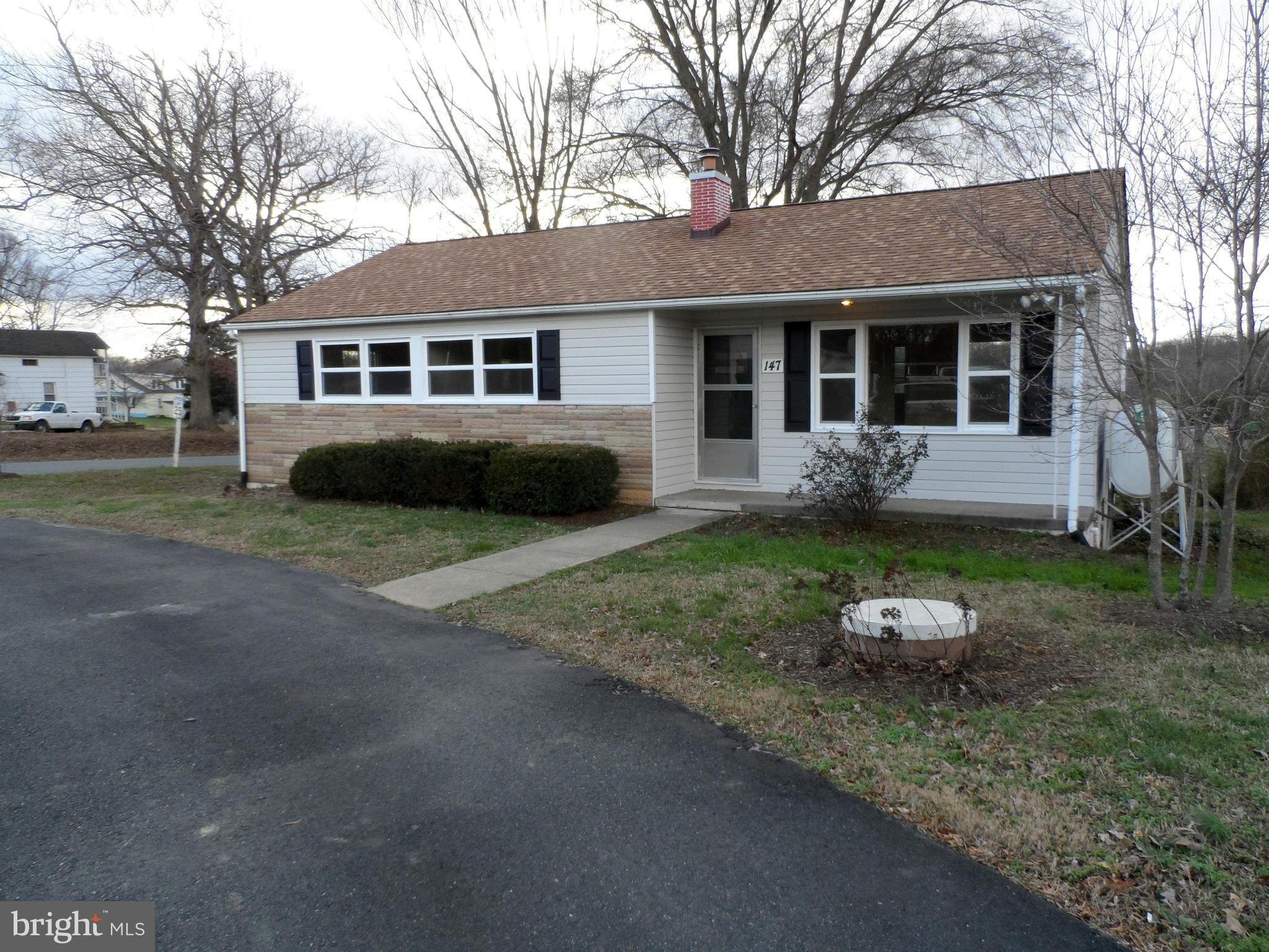 a front view of a house with a yard and trees