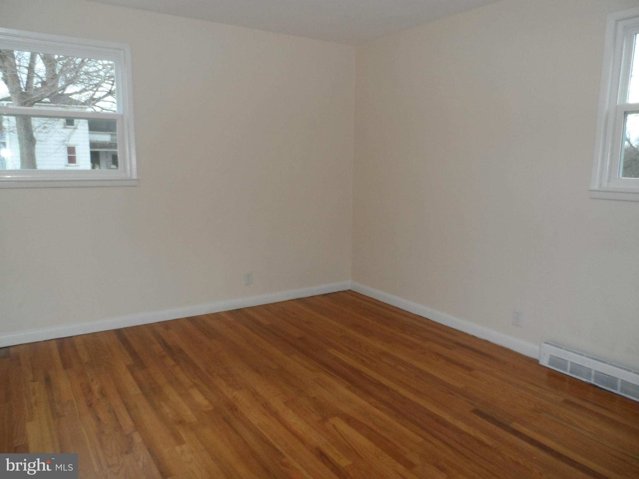 147 Deacon Road Fredericksburg, VA 22405 - Photo 9 of 16 an empty room with wooden floor and windows