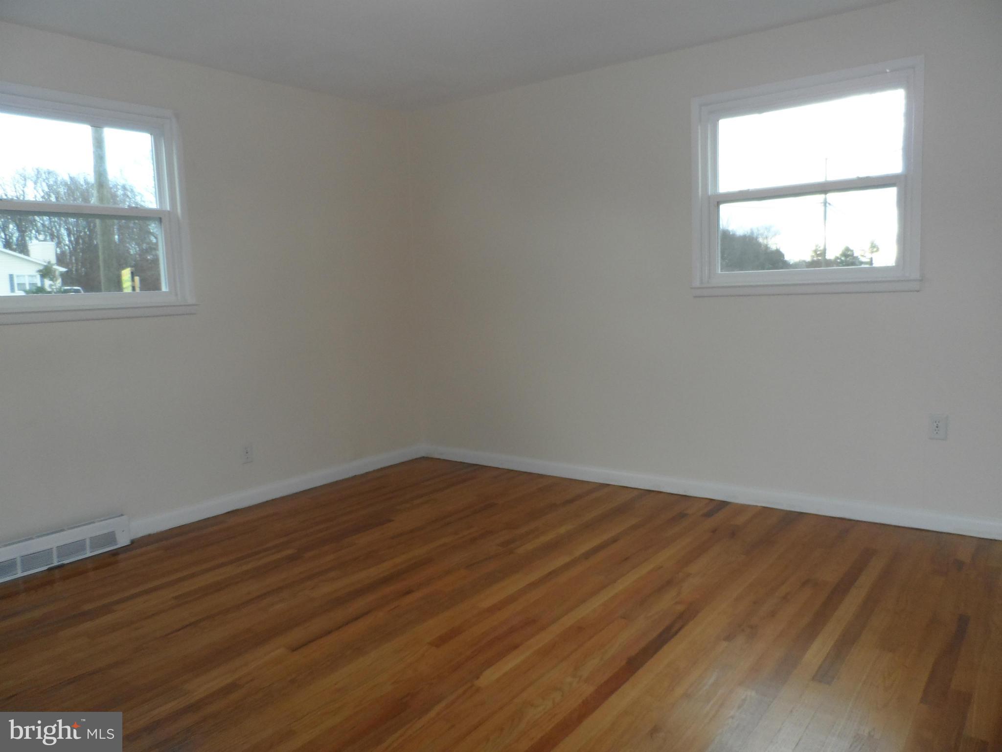 147 Deacon Road Fredericksburg, VA 22405 - Photo 10 of 16 an empty room with wooden floor and windows