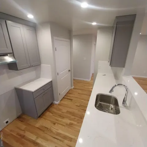 a living room with hard wood flooring and a sink