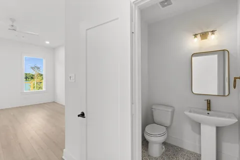 a bathroom with a toilet sink and mirror