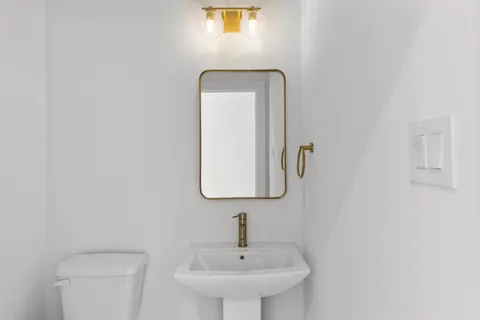 a bathroom with a toilet sink and mirror