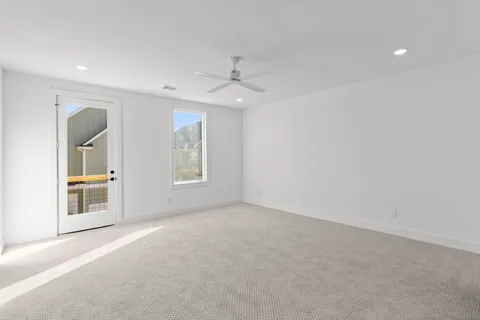 en empty room with windows and ceiling fan