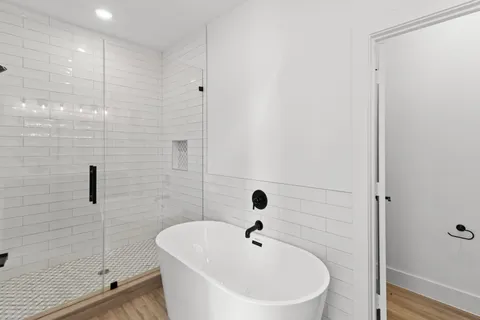 a white bath tub sitting next to a shower
