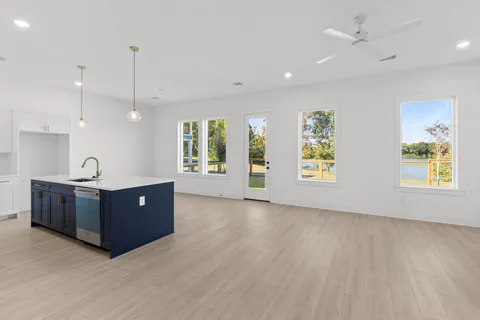 a view of a kitchen with a sink a window and wooden floor