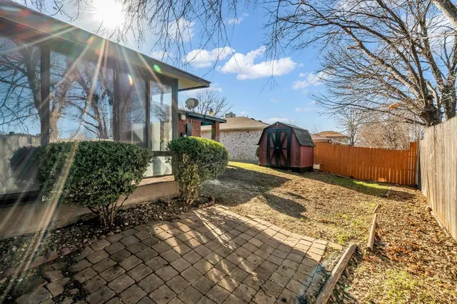 a view of a house with a small yard and large tree