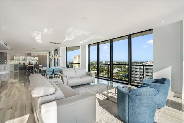 a living room with furniture and a large window with balcony view