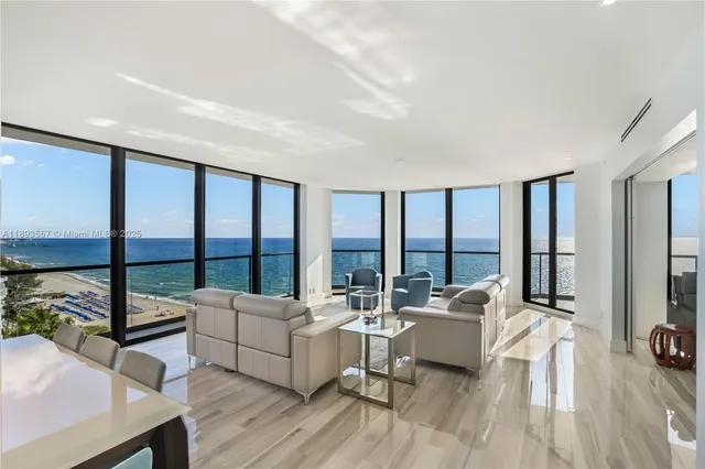 a living room with furniture and a large window with balcony view