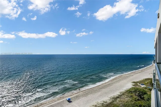 a front view of a building with a yard and plants