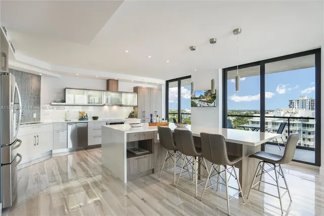 a large white kitchen with wooden floor and stainless steel appliances
