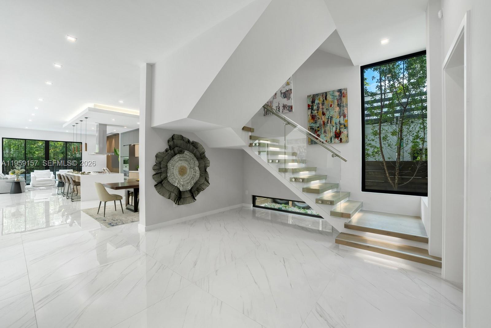 1780 Chucunantah Road Miami, FL 33133 - Photo 5 of 34 a room with lots of white furniture a rug and a large window