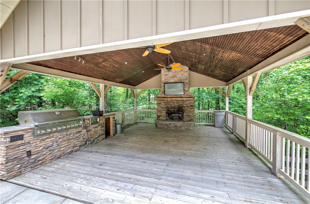 561 Holland Road Dallas, GA 30157 - Photo 42 of 48 a view of a patio with table and chairs a barbeque with wooden floor and fence