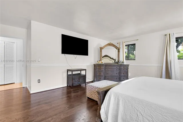 a spacious bedroom with a bed and a flat screen tv