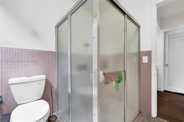 a bathroom with a toilet and a shower