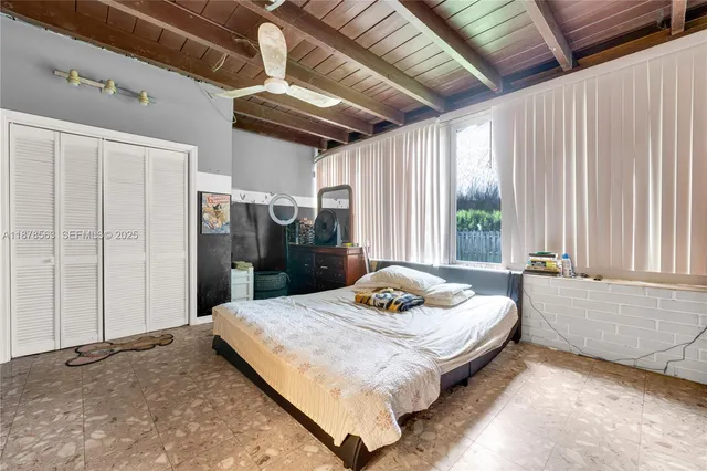 a bed sitting in a spacious bedroom next to a window