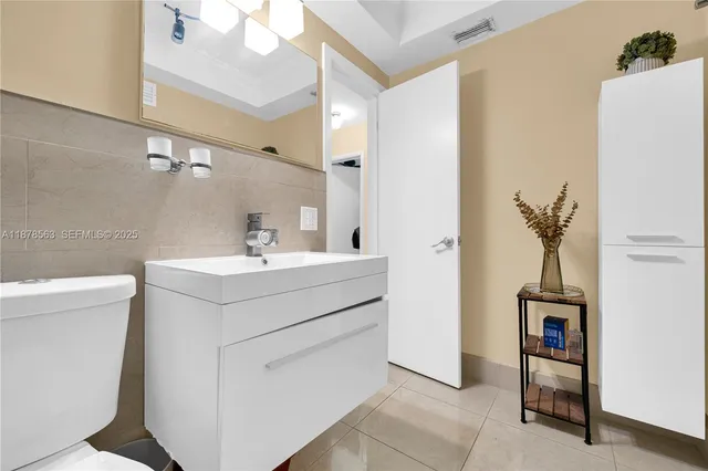 a bathroom with a sink mirror and vanity
