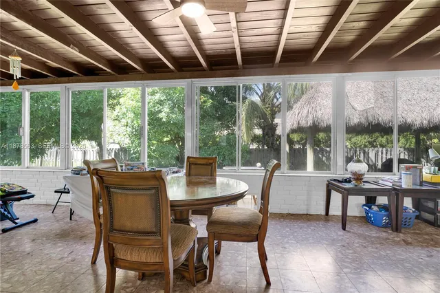a dining room with furniture large windows and a chandelier