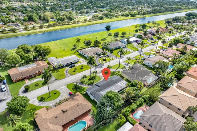 an aerial view of residential houses with outdoor space and swimming pool