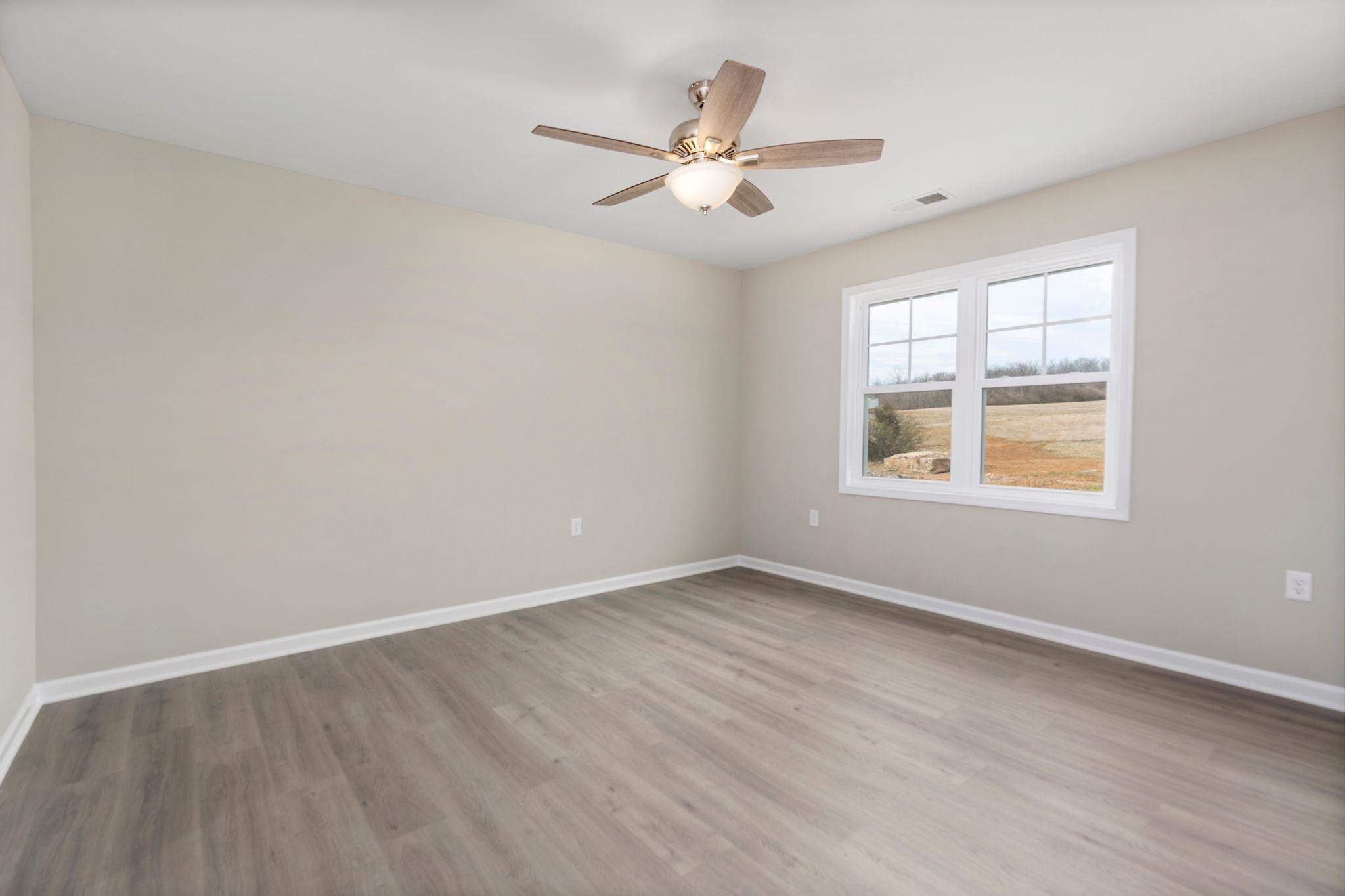 205 Spring Run Lane Waynesboro, VA 22980 - Photo 15 of 35 an empty room with wooden floor ceiling fan and windows