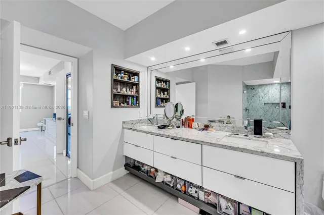 a bathroom with a double vanity sink mirror and shower