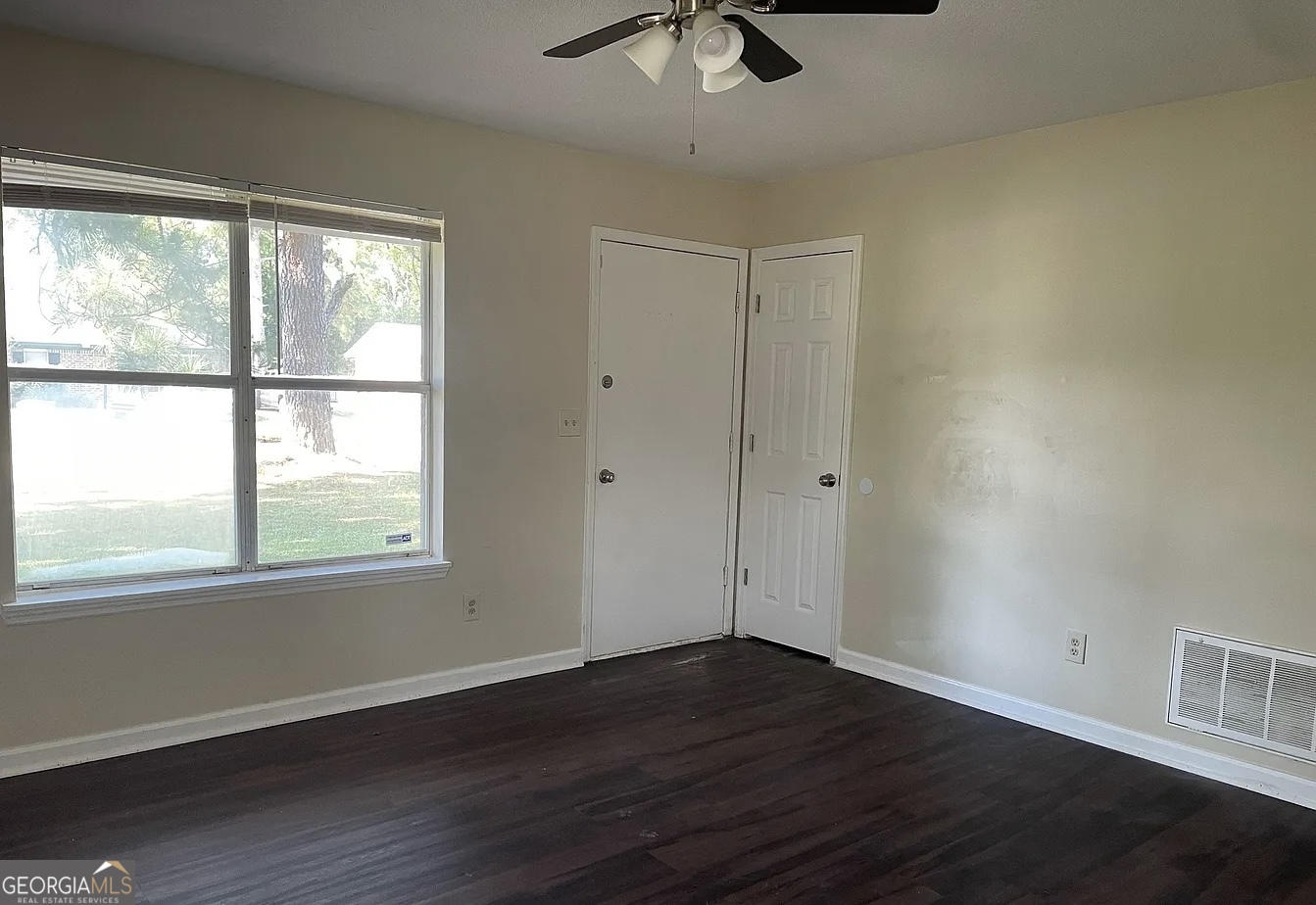 538 Southgate Avenue Albany, GA 31701 - Photo 2 of 16 a view of an empty room with wooden floor and a window