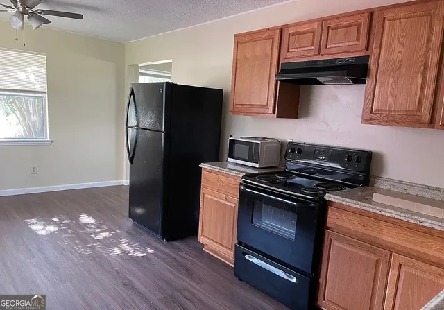 a kitchen with granite countertop wooden cabinets and a stainless steel appliances